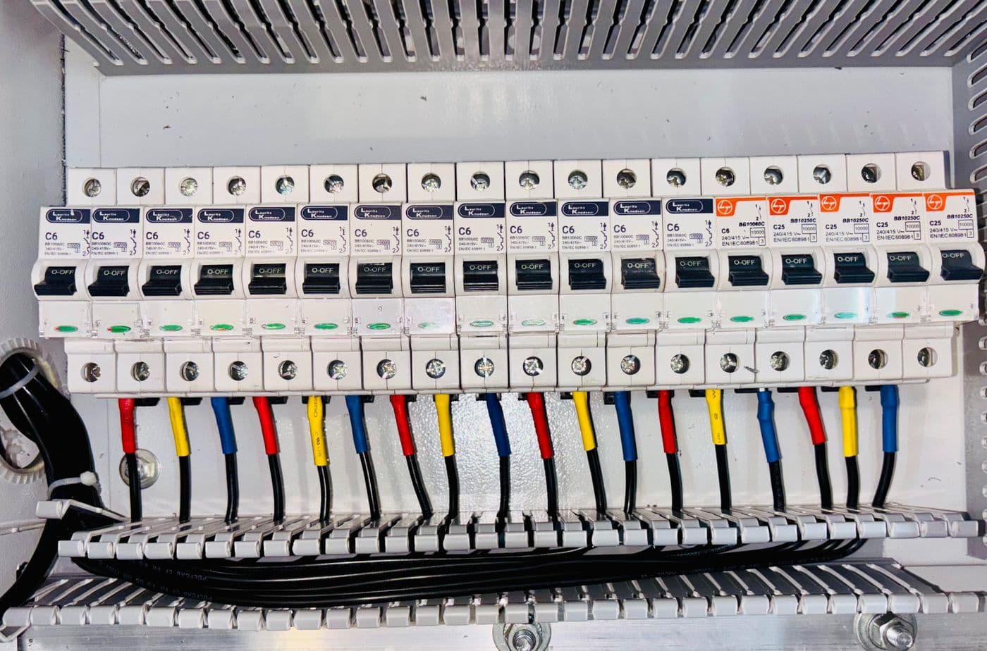 Colour-coded miniature circuit breakers mounted on a distribution board rail