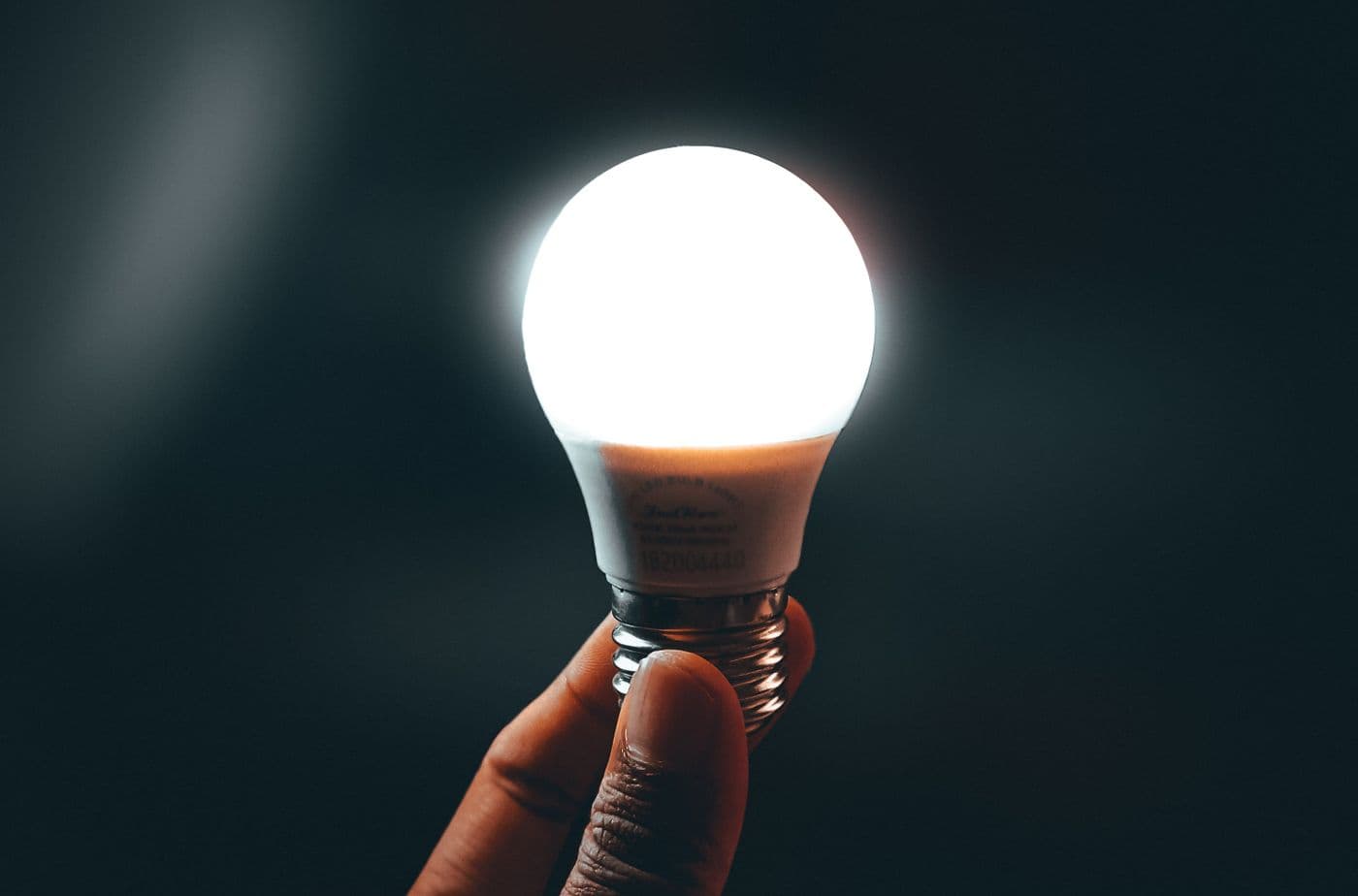 LED bulb held in hand before installation in a home light fitting